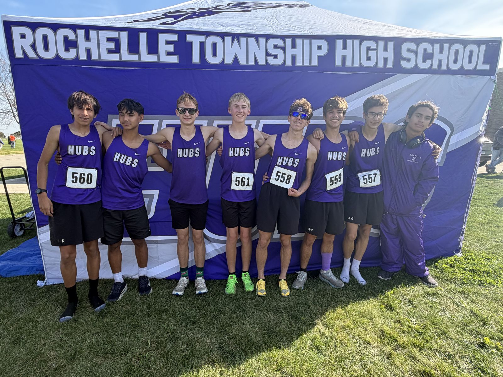 The Rochelle Hubs boys varsity cross country team in front of the RTHS tent at the Belvidere Regional